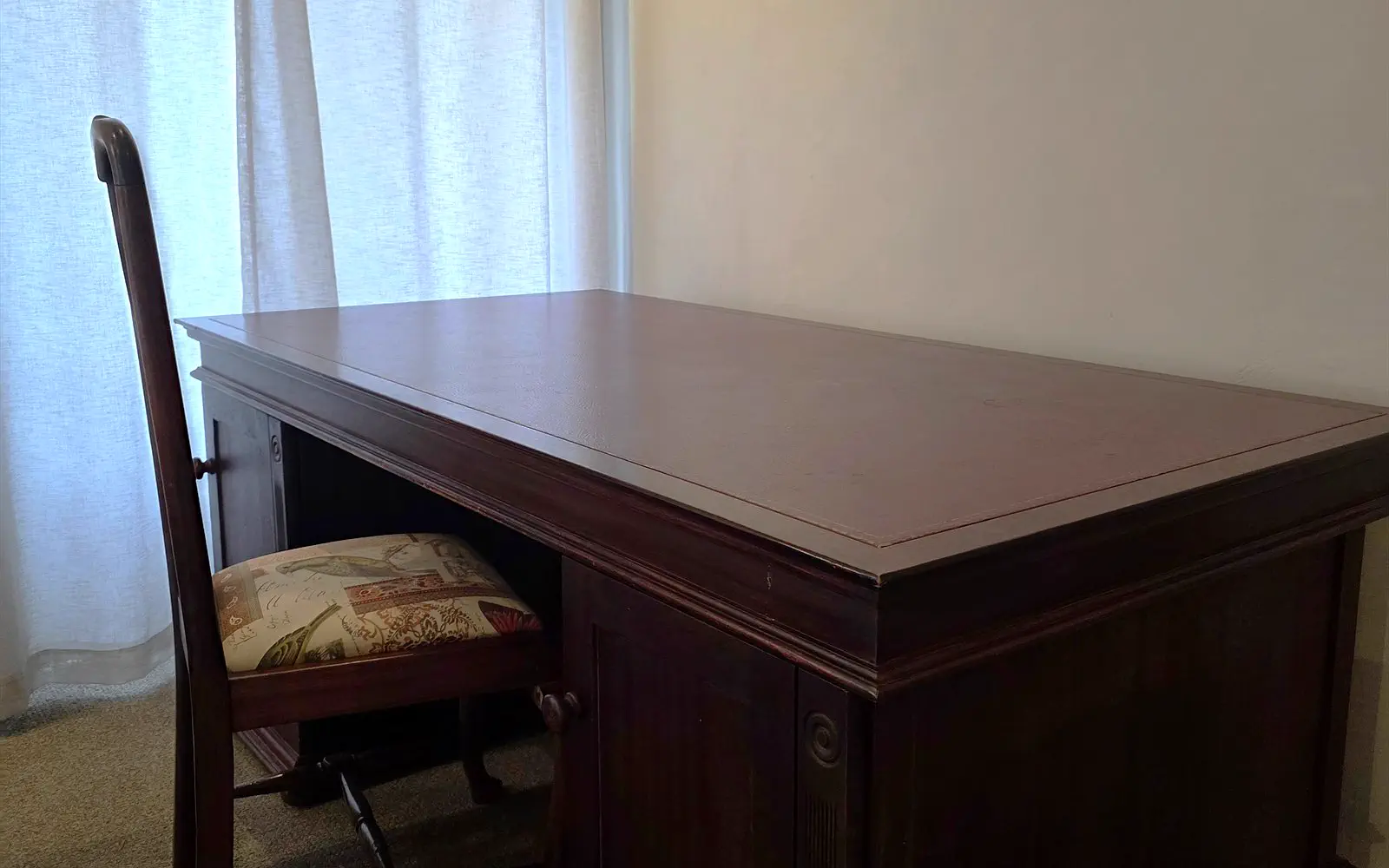 Mahogany desk with chair by the window in The Library
