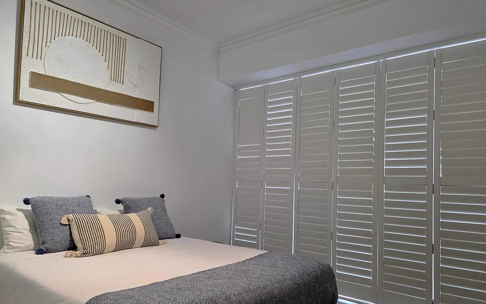 The Lodge bed with artwork and a white shutter wall