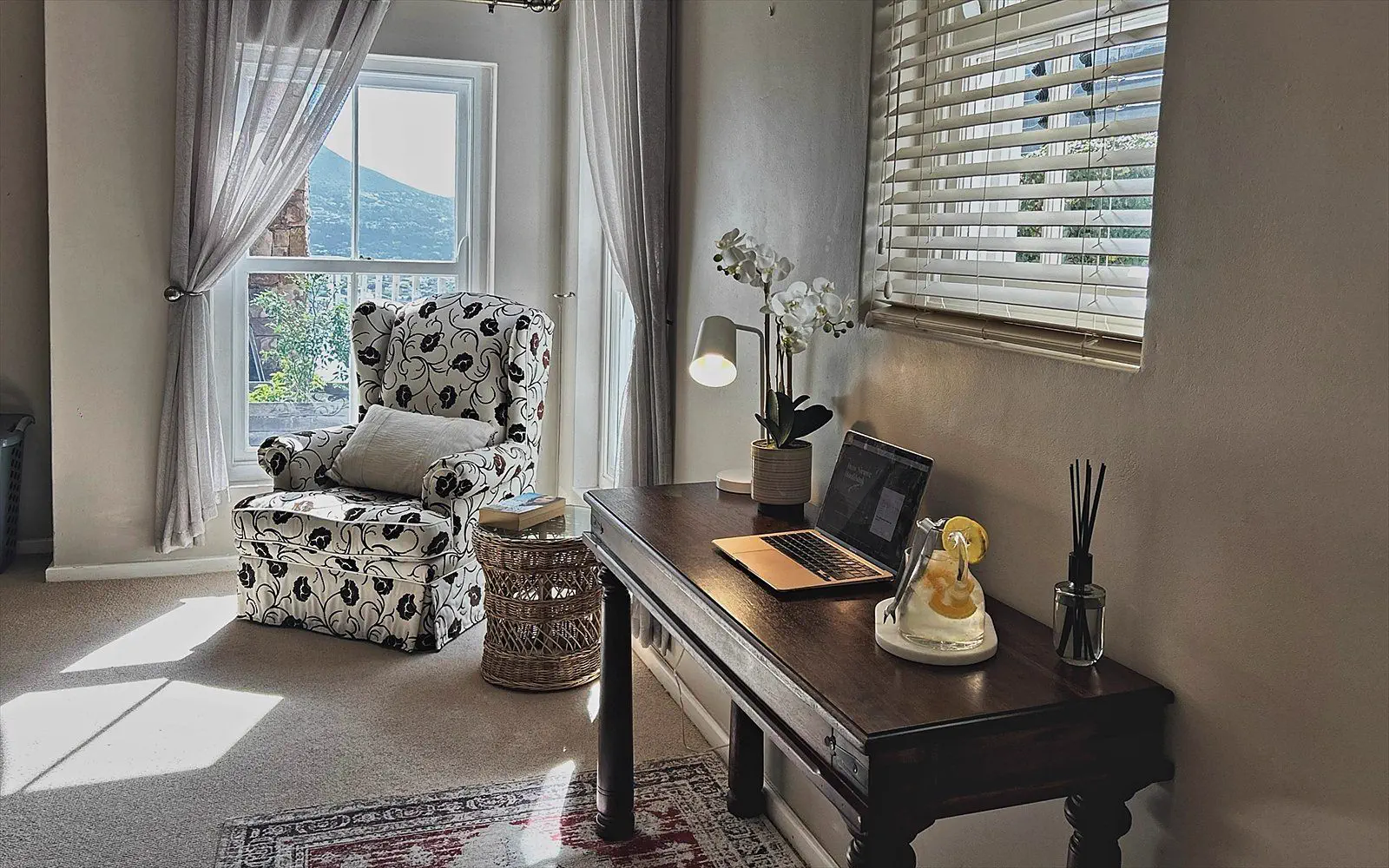 Floral wingback chair by the window with a view of the mountain