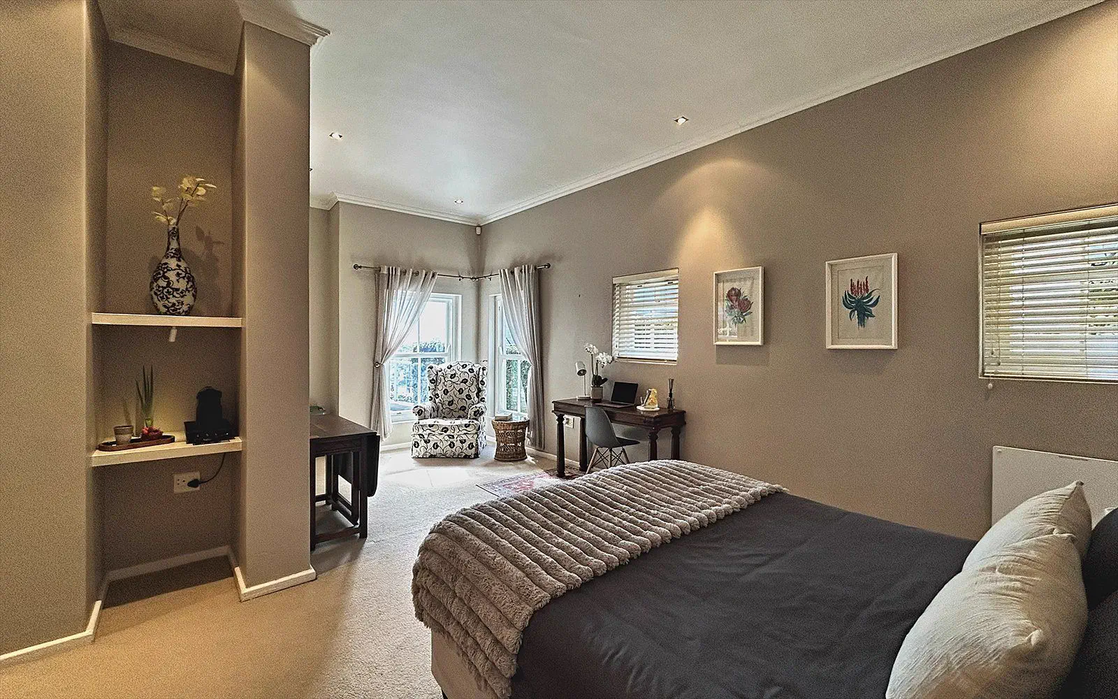 Spacious bedroom with alcoves, seating area and double bed