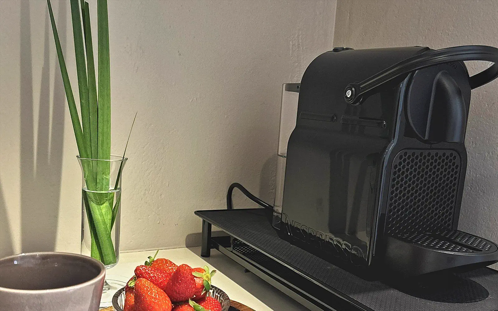 Espresso machine with cups, a mug and fresh strawberries