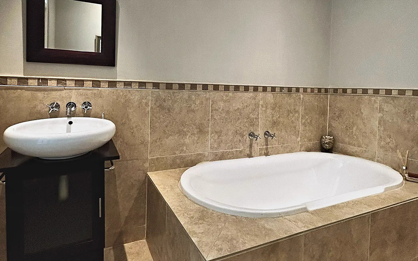 Basin with mirror beside the bath