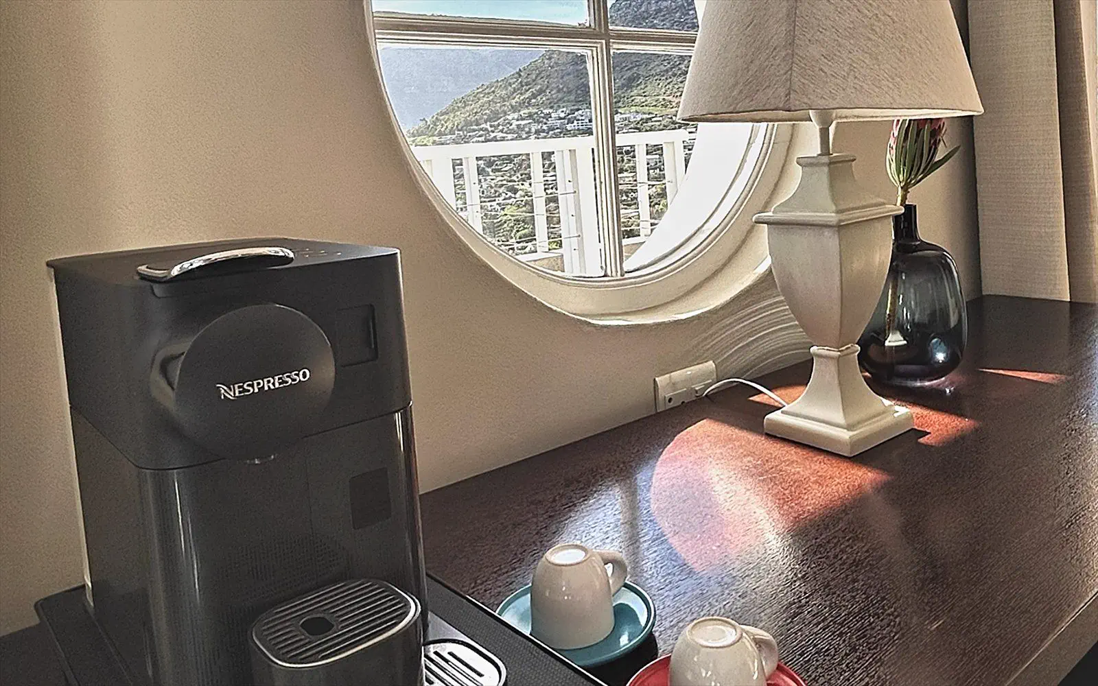 Espresso machine with cups on the sideboard, beside the round window