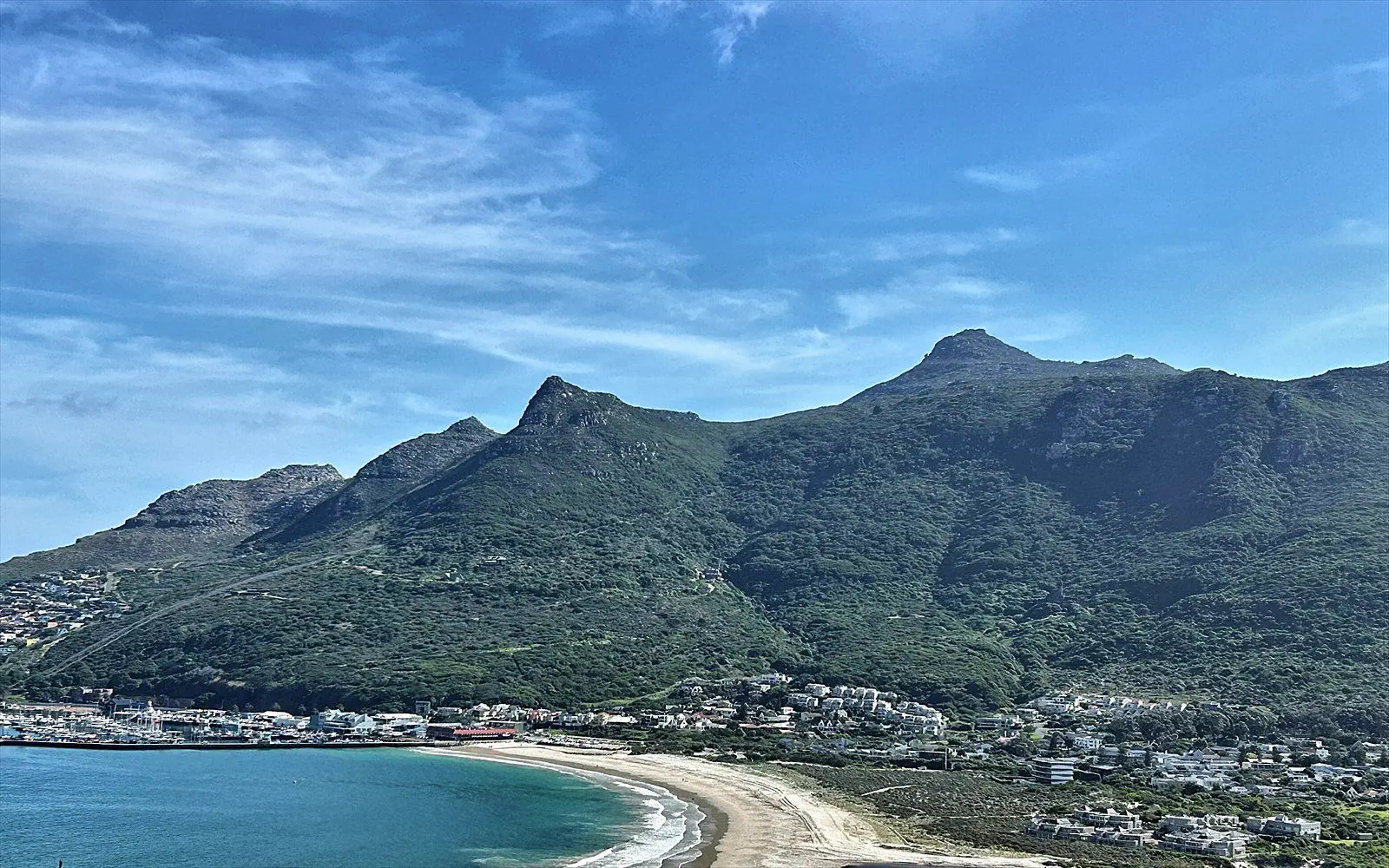 Wide view over the bay of Hout Bay, the beach and the surrounding mountains