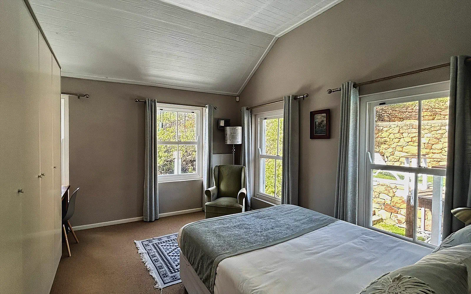Second sleeping area of The Split with two windows, an armchair and its own bed