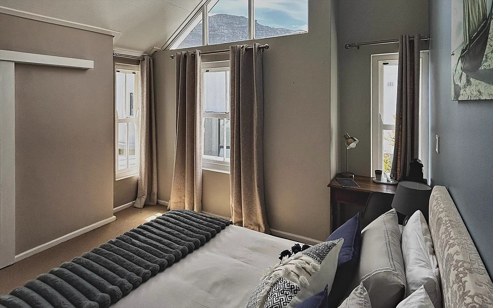High sloping ceiling with a gable window and a view of the mountains